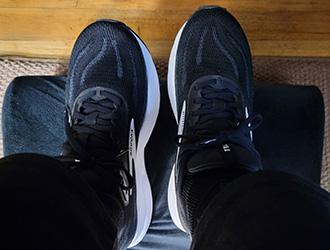 Feet resting on office under-desk foot rest